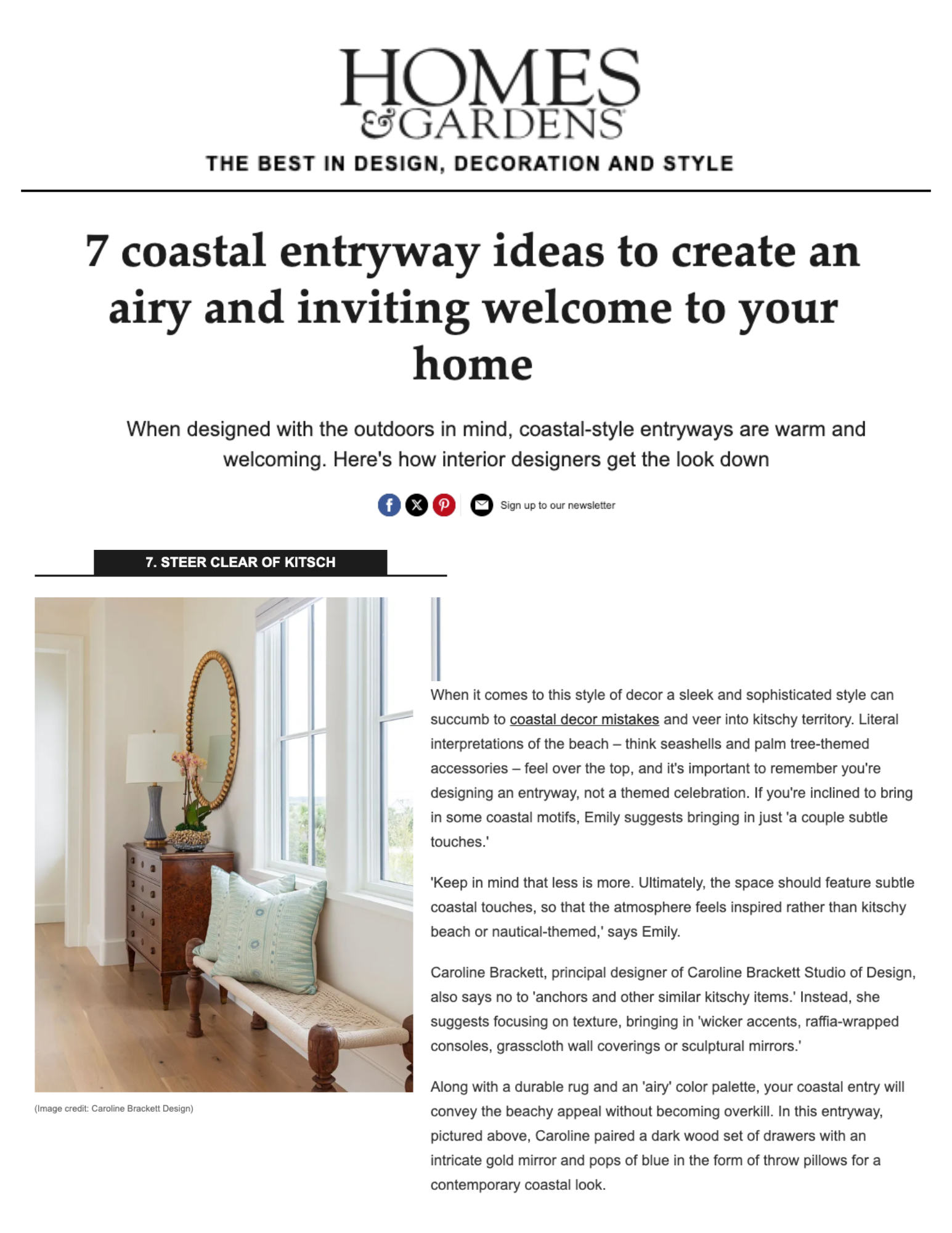 Interior of a coastal-themed entryway with a white bench, green and blue pillows, a wooden dresser with a white lamp, a mirror with a wicker frame, and a window showing greenery outside.
